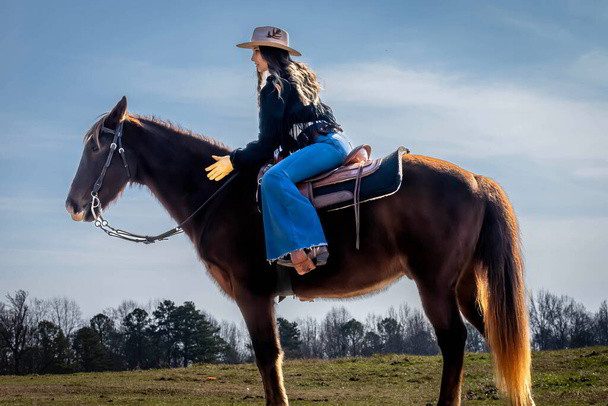 mujer sombrero-de-vaquero-mientras-se-monta-a-caballo