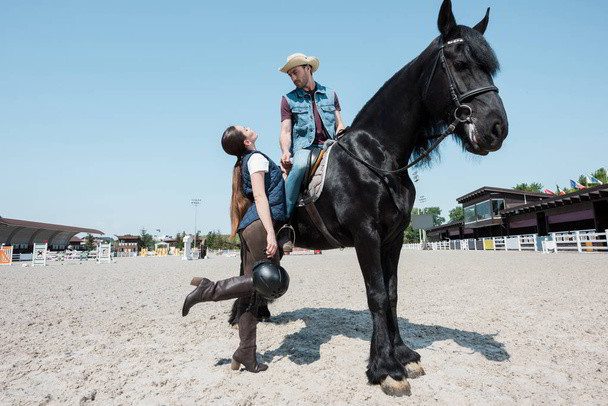 usar un sombrero de vaquero mientras se monta a caballo